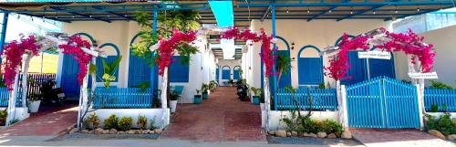 a hallway of a building with blue gates and pink flowers at Homestay Văn Vĩnh Hy 4 in Vĩnh Hy