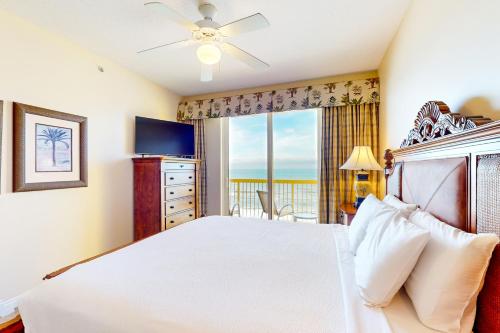 a bedroom with a bed and a window with a view at Calypso 906W in Panama City Beach