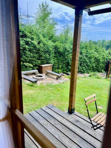 a view of a porch with a bench on the grass at Log cabins at Iron Rose in Czech Canada in Nová Bystřice