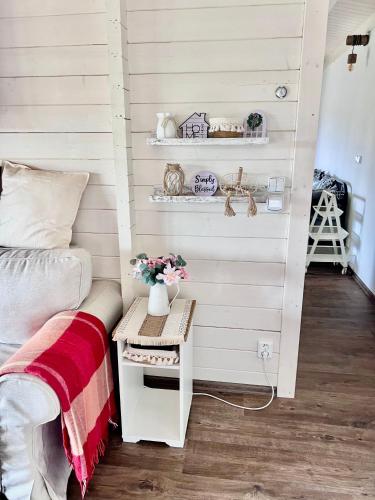 a bedroom with white walls and a bed and a table at Log cabins at Iron Rose in Czech Canada in Nová Bystřice