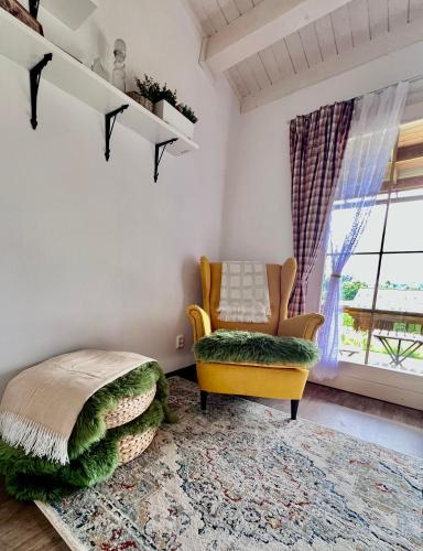 a living room with a yellow chair and a rug at Log cabins at Iron Rose in Czech Canada in Nová Bystřice