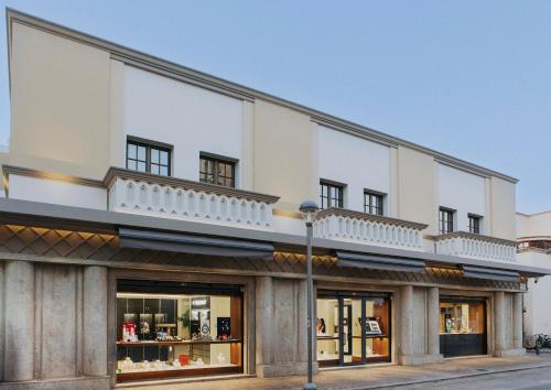 a large white building with a balcony on top at Volaka Luxury Suites in Kos Town