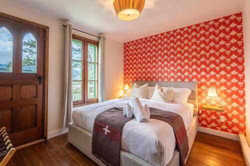 una camera da letto con un letto con una parete rossa di Chalet Ernest Feuz - Edelweiss Village a Golden