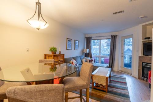 a living room with a table and chairs and a couch at Alpine Village Condo by Canadian Rockies Vacation Rentals in Canmore
