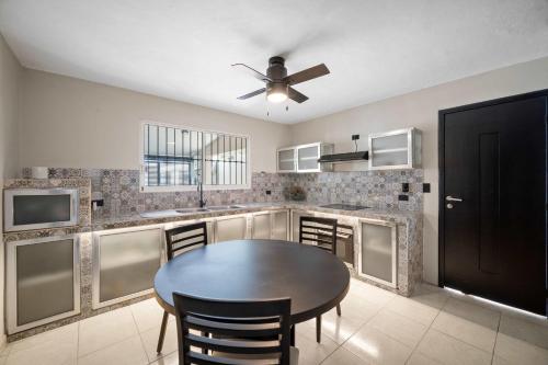 eine Küche mit einem Tisch und einem Deckenventilator in der Unterkunft ALTABRISA Casa Familiar en Merida in Mérida