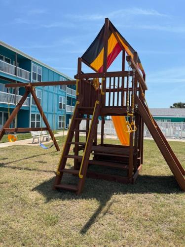 a playground with a slide in front of a building at Executive Keys Condominiums on the Beach in Port Aransas