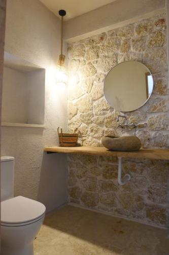 a bathroom with a white toilet and a mirror at Village Escape House by CorfuEscapes in Lefkimmi