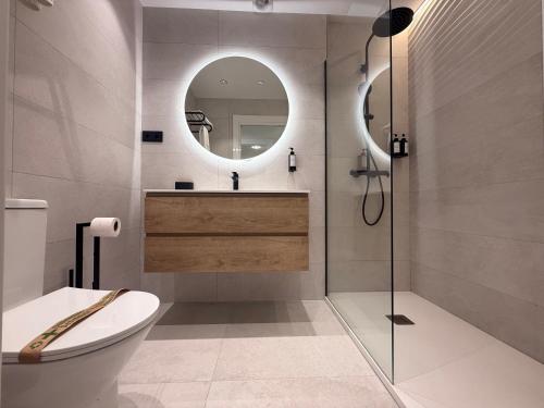 a bathroom with a toilet and a sink and a mirror at Playa de los Locos con Garaje Recién Reformado!! in Suances
