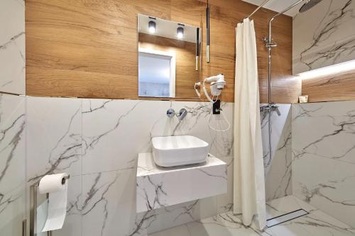 a bathroom with a sink and a shower at Leśny Dworek - Pokoje & Apartamenty in Białka Tatrzanska