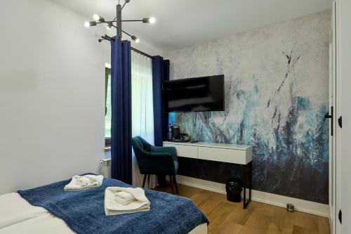 a bedroom with a bed and a desk and a wall at Leśny Dworek - Pokoje & Apartamenty in Białka Tatrzanska