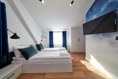 a bedroom with a bed and a flat screen tv at Leśny Dworek - Pokoje & Apartamenty in Białka Tatrzanska