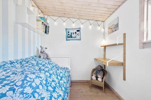 a bedroom with a blue and white bed and a shelf at R619-Rodvig-Gogevej-4 in Rødvig