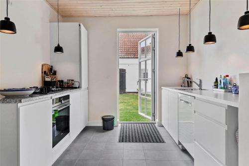 a kitchen with white cabinets and a door to a yard at 3039-Stege-Stejlepladsen-1-3 in Stege