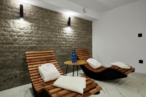 two wooden chairs and a table in a room at Leśny Dworek - Pokoje & Apartamenty in Białka Tatrzanska