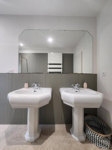 a bathroom with two sinks and a large mirror at Villa Piscine près Golf Arcachon in La Teste-de-Buch
