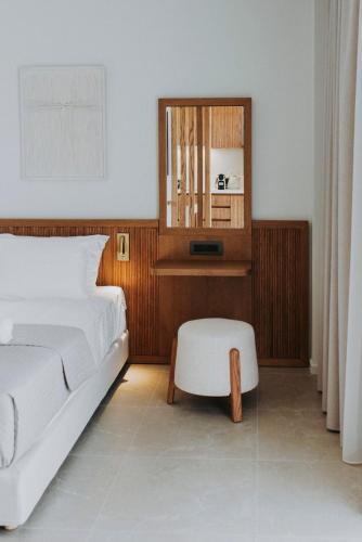 a bedroom with a bed and a chair and a mirror at Volaka Luxury Suites in Kos Town