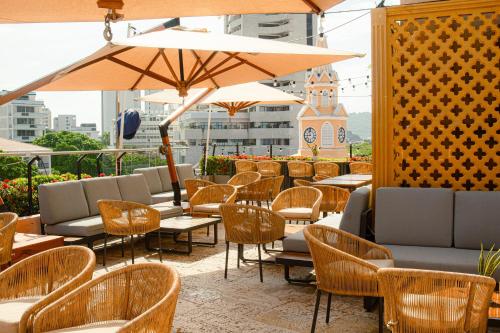 a restaurant with chairs and tables and an umbrella at Hotel Santa Catalina By OxoHotel in Cartagena de Indias