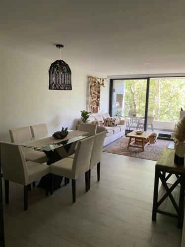 a living room with a table and chairs and a couch at Acogedor departamento de lujo in Pucón