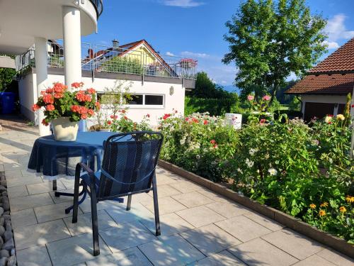 a blue table with a vase of flowers on a patio at Ferienwohnung Schiffner in Hengnau