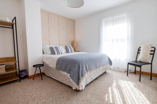 a bedroom with a bed and a window and a chair at SeaBreeze Portstewart in Portstewart