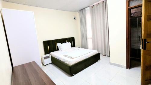 a bedroom with a bed in a white room at Kigali Nice Apartment in Kigali