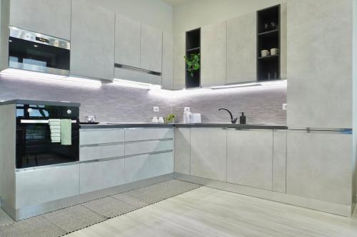 a kitchen with white cabinets and a sink at Space and comfort a stone's throw from Milan and Linate in Pioltello