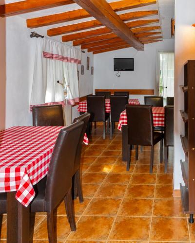 a dining room with a red and white table and chairs at Pensiunea Nordica in Statiunea Borsa