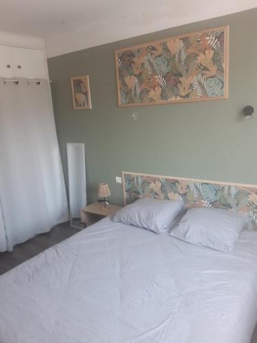 a bedroom with a white bed with a picture on the wall at 1er etage d'une maison in Sorgues
