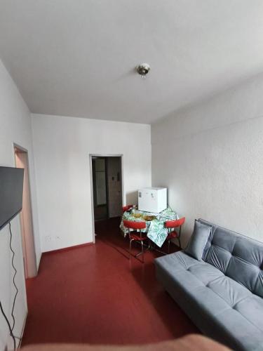 a living room with a couch and a table with a laptop at Apartamento na RETA de Teresópolis in Teresópolis