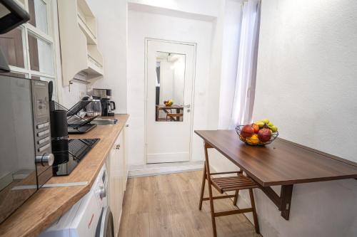 a kitchen with a bowl of fruit on a wooden table at La Casa di Symi - Central Apartment with View in Symi
