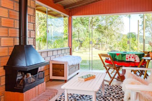 a screened in porch with a fireplace and a table at Casa de campo c lareira, jogos e piscina aquecida in Annitapolis