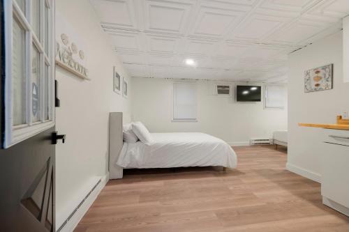 a bedroom with a bed in a room with white walls at The Beachside in Sylvan Beach