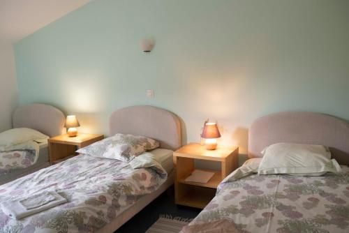 2 lits dans une chambre avec 2 lampes sur des tables dans l'établissement La Hulotte- Brocéliande, à Saint-Malon-sur-Mel