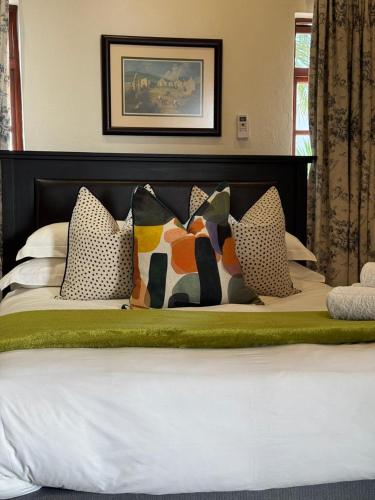 a bed with many pillows on top of it at Rivonia Garden Suites in Johannesburg