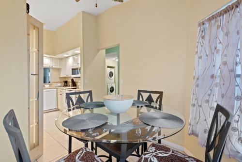 a dining room with a glass table and chairs at Siren’s Song, Minutes to IMG & Anna Maria Island in Bradenton