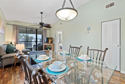 a dining room with a glass table and chairs at Siren’s Song, Minutes to IMG & Anna Maria Island in Bradenton