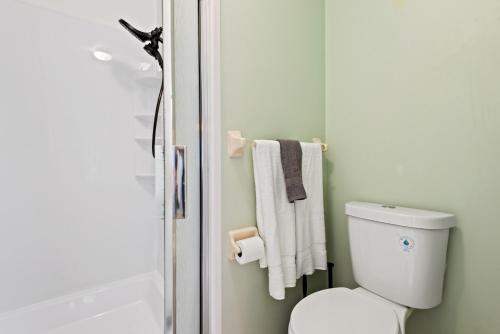 a bathroom with a toilet and a shower with towels at Siren’s Song, Minutes to IMG & Anna Maria Island in Bradenton