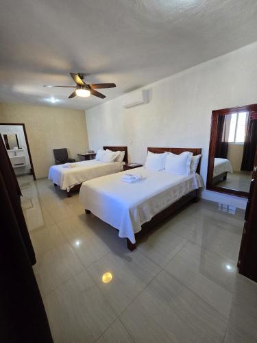a hotel room with two beds and a ceiling fan at Hotel Casa Garatusa in Yuriria