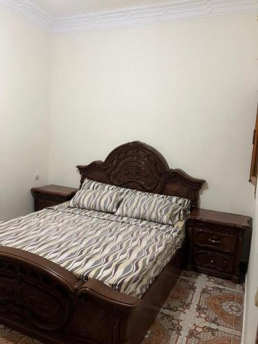 a bed with a wooden headboard in a bedroom at Piso para alquiler in Martil