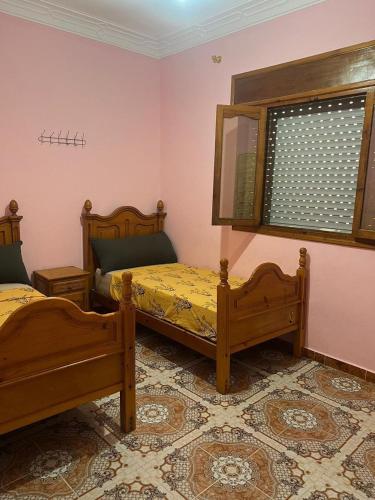a bedroom with two beds and a window at Piso para alquiler in Martil