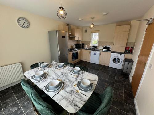 a kitchen and dining room with a table and chairs at DONALD'S Townhouse - INVOICE and REDUCED PRICE only via ORION SHORT STAYS DUNDEE, 4 Room, 3 bath, Ring Road Access, Fully Equipped, Free Parking - Freshly Renovated in Dundee