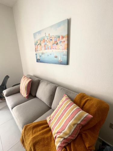 a living room with a couch and a painting on the wall at Luxi Apartment Teulada in Teulada