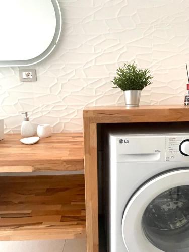 a laundry room with a washing machine and a mirror at Luxi Apartment Teulada in Teulada
