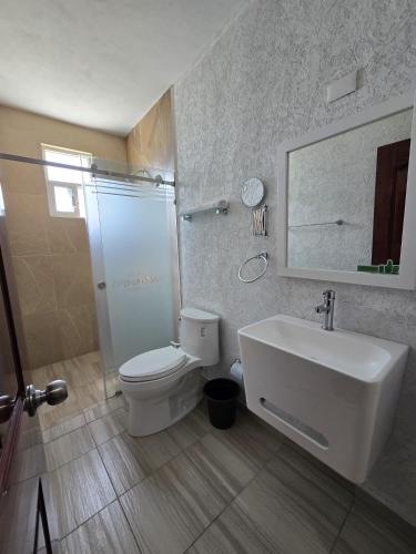 a bathroom with a sink and a toilet and a mirror at Hotel Casa Garatusa in Yuriria