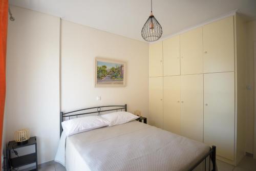 a bedroom with a bed and a painting on the wall at DM Apartment 2 - Only 4' from Rafina Port & 2' from the beach in Rafina