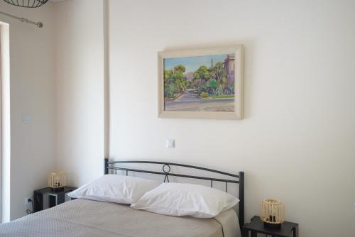 a bedroom with a bed with a picture on the wall at DM Apartment 2 - Only 4' from Rafina Port & 2' from the beach in Rafina