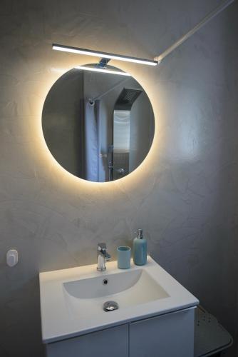a bathroom with a white sink and a mirror at DM Apartment 2 - Only 4' from Rafina Port & 2' from the beach in Rafina