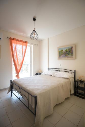 a bedroom with a large bed in front of a window at DM Apartment 2 - Only 4' from Rafina Port & 2' from the beach in Rafina