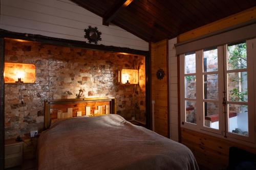 ein Schlafzimmer mit einem Bett in einer Steinmauer in der Unterkunft La Cábala del Draguillo in Santa Cruz de Tenerife
