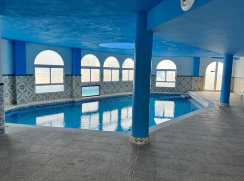 a swimming pool with blue columns in a building at perla blanca in Peñíscola